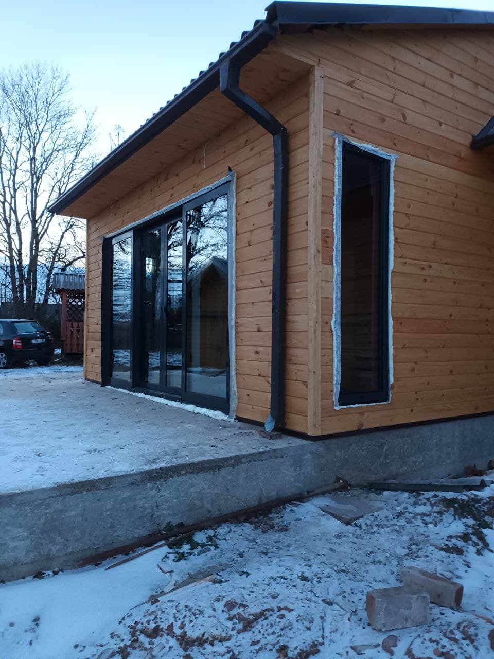 Namas su aliuminio langais ir medžio fasadu