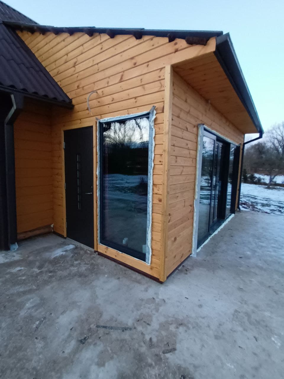Medinio namo langai ir įėjimas tamsiais rėmais