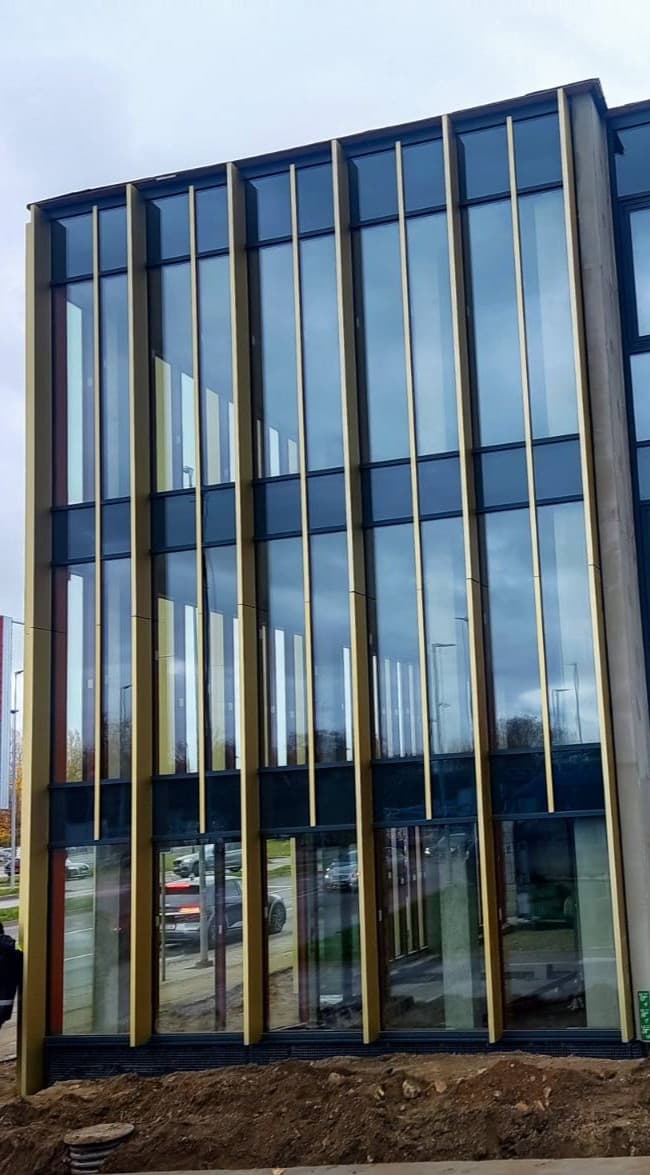 Vertikalus stiklo fasadas komerciniame pastate